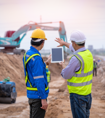 Arquitecto y aparejador revisando algo en una tablet en una obra